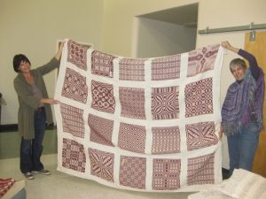 Therese May and Jan DeShera with quilt top.