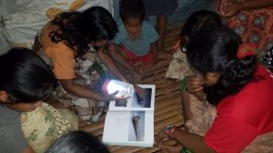 Weavers studying pattern book